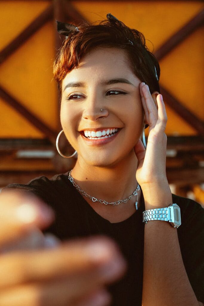 Portrait of a smiling woman with hoop earrings, enjoying outdoors.
